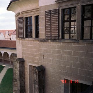 Historic courtyard with arched colonnade, old town spires.