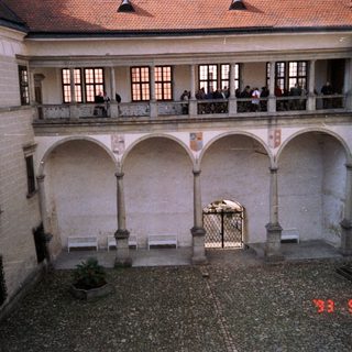 Historic courtyard with arched galleries and stone flooring.