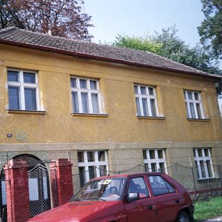 Yellow two-story building with peeling paint.