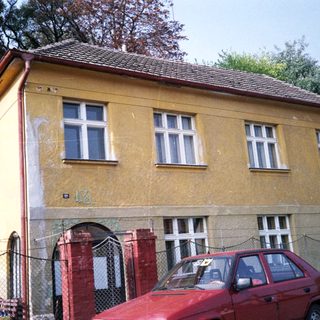 Yellow two-story building with peeling paint.