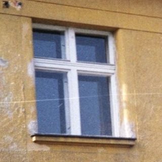 Yellow two-story building with peeling paint.