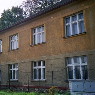 Two-story building with aged stucco exterior.