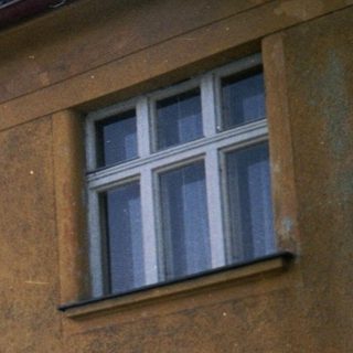Two-story building with aged stucco exterior.