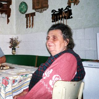 Three elderly people sitting together indoors at a table.