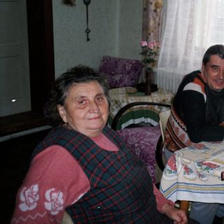 Family gathered around table with cake indoors.