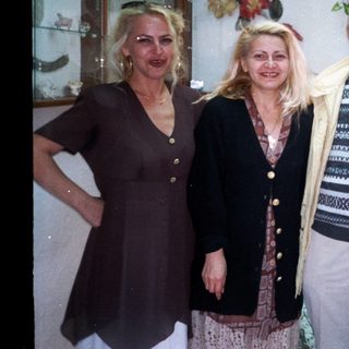 Four people posing together indoors near decorative items.