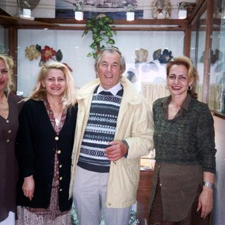 Four people posing together indoors near decorative items.