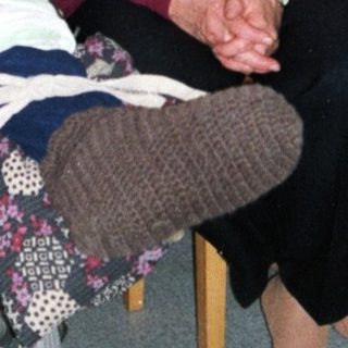 Two elderly individuals sitting together indoors.