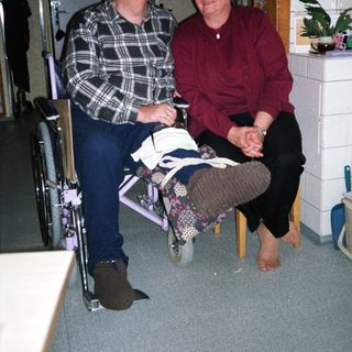 Two elderly individuals sitting together indoors.
