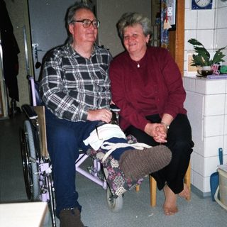Two elderly individuals sitting together indoors.