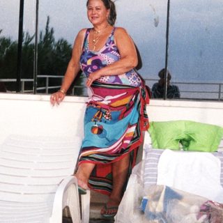 Woman in colorful dress on rooftop patio.