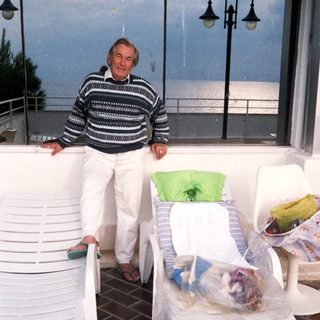 Man relaxing on patio by ocean view.