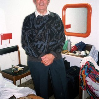 Man standing in a simple hotel room.