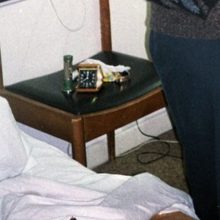 Man standing in a simple hotel room.