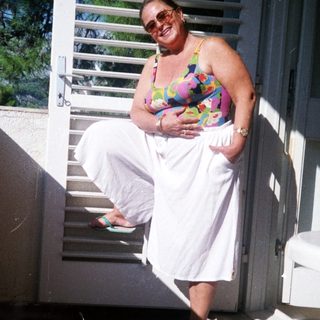 Woman holding baby on outdoor stairs.