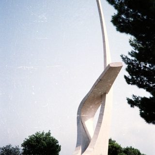 Modern abstract concrete monument resembling a wing.