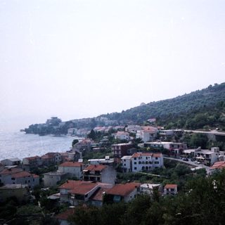 Coastal village nestled by sea and hills.