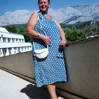 Woman smiling outdoors in mountain landscape.