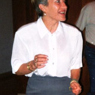 Two people laughing and conversing indoors at an event.