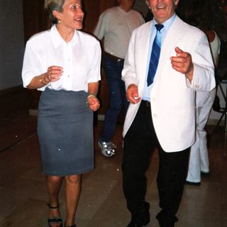 Two people laughing and conversing indoors at an event.