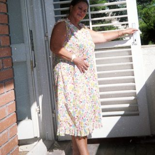 Woman standing outside near open door.