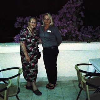 Two people posing together outdoors at night.
