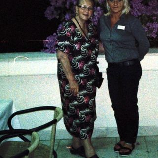 Two people posing together outdoors at night.