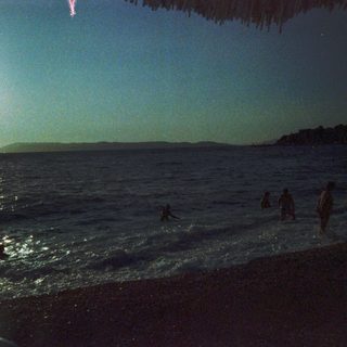 Sunset or sunrise at a beach with silhouetted figures.