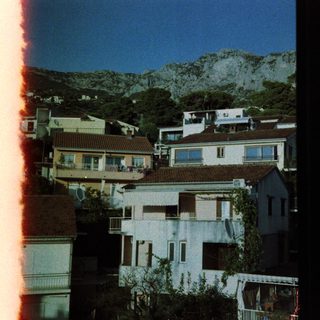 Coastal town houses with mountain backdrop.
