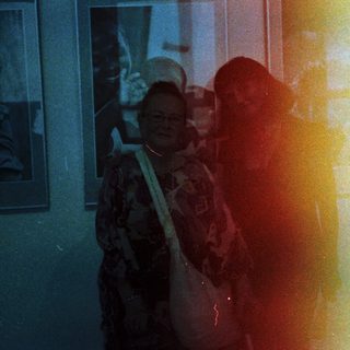 People viewing art exhibition indoors.