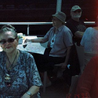 Group of elderly people posing indoors at a table.