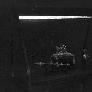 Illuminated crown on dark background.