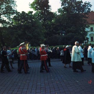 Traditional brass band performing outdoors with onlookers.