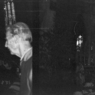 Dark church interior with illuminated stained glass.
