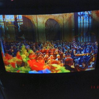 Concert hall audience watching large orchestra performance.