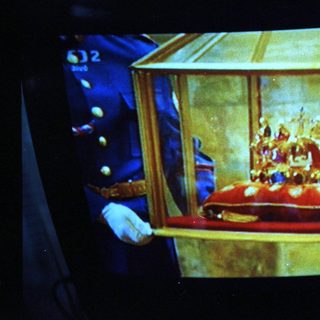 Golden ceremonial crown in ornate display case.