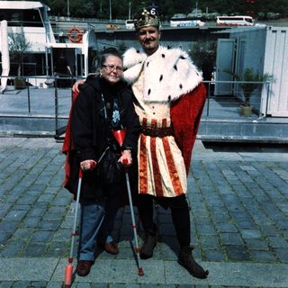 Two people dressed in medieval costumes posing outdoors.