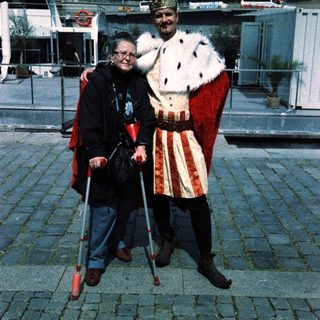 Two people dressed in medieval costumes posing outdoors.