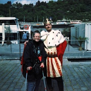 Two people posing: one in medieval costume, one using a cane.