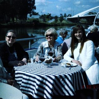 Group enjoying outdoor meal by water.