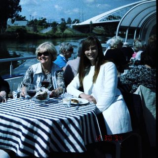 Group enjoying outdoor meal by water.
