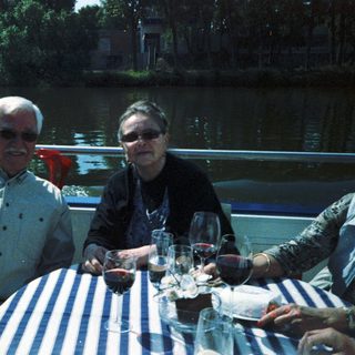 Two people enjoying drinks by a waterfront table.
