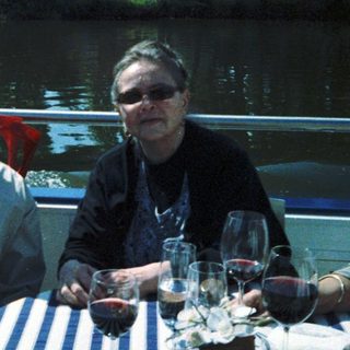Two people enjoying drinks by a waterfront table.