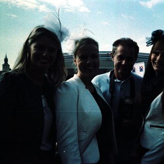 Four people posing happily by a waterfront.