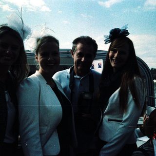 Four people posing happily by a waterfront.