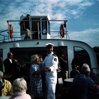 Boat gathering with crew and passengers on deck.