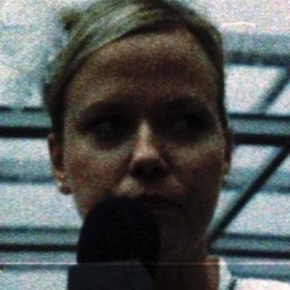 Person speaking into microphone on stage.