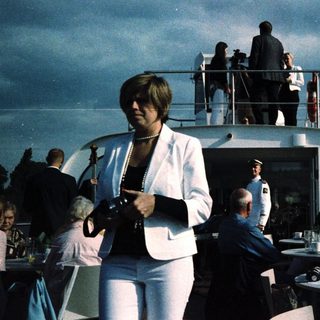 Luxury boat party with guests on deck.