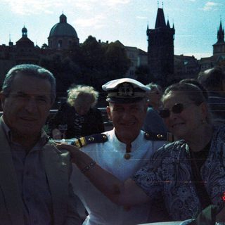 People posing with Prague skyline in background.
