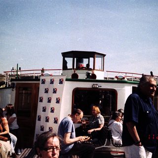 Boat with passengers and crew on river.